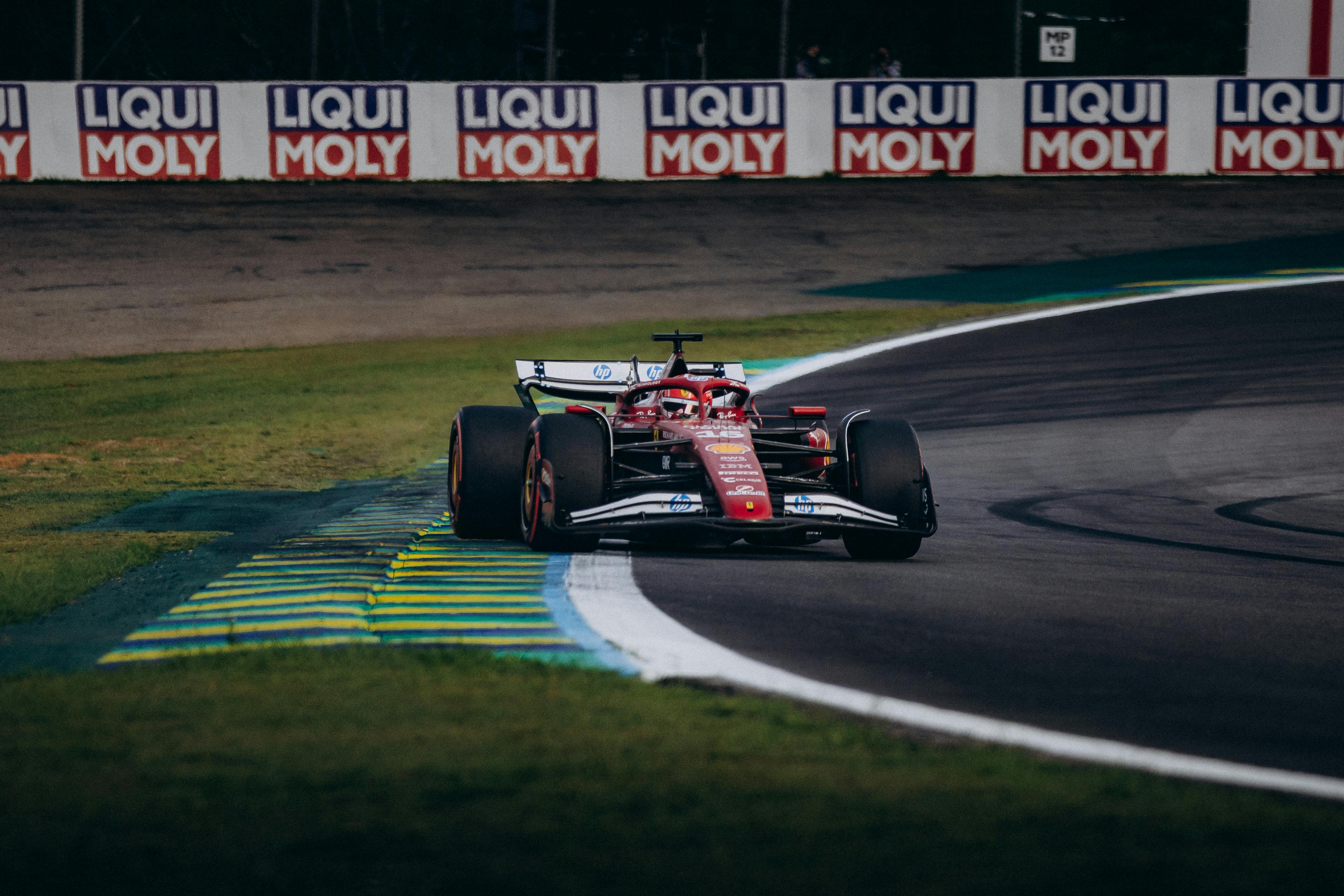 Futurystyczny bolid Formuły 1 z aktywną aerodynamiką na torze Silverstone o zmierzchu z LED-ami.